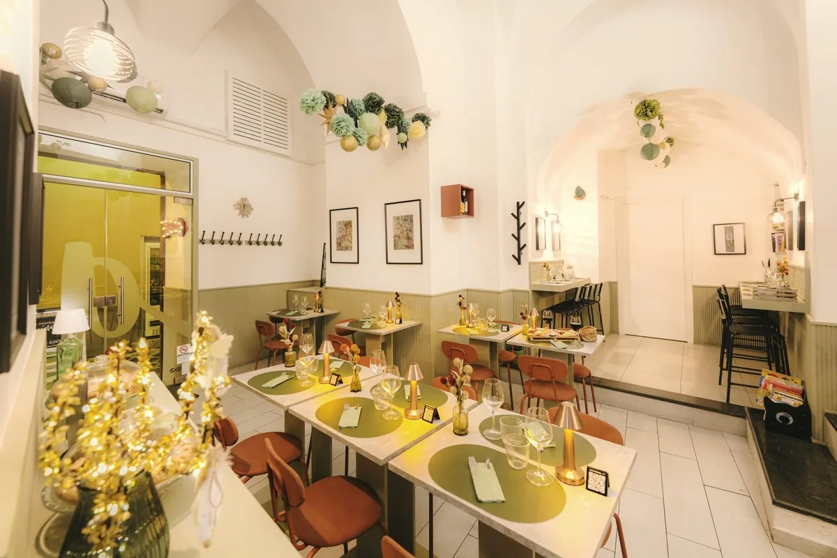 The dining room at Assaf&agrave;, with the tables laid and the pale walls of the inside room
