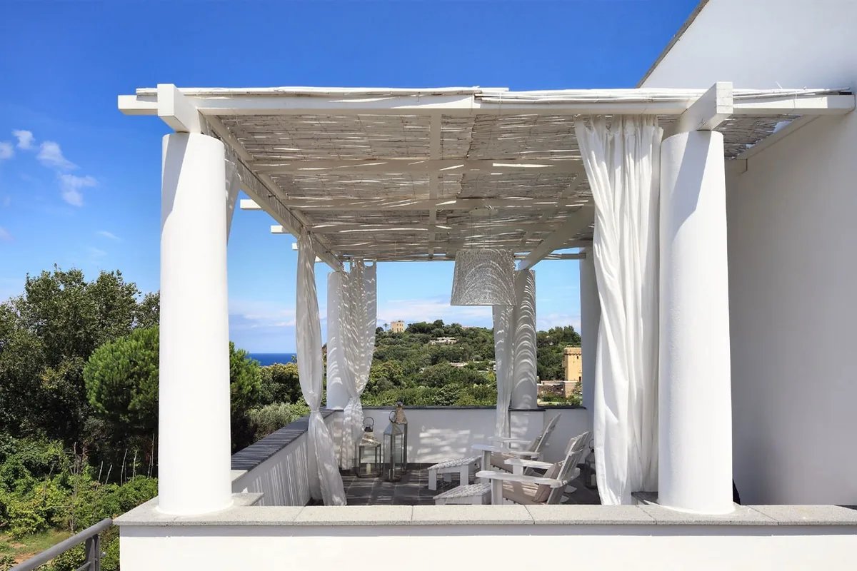 The terrace with its white pergola at La Suite Hotel & Spa, open onto the greenery of the island